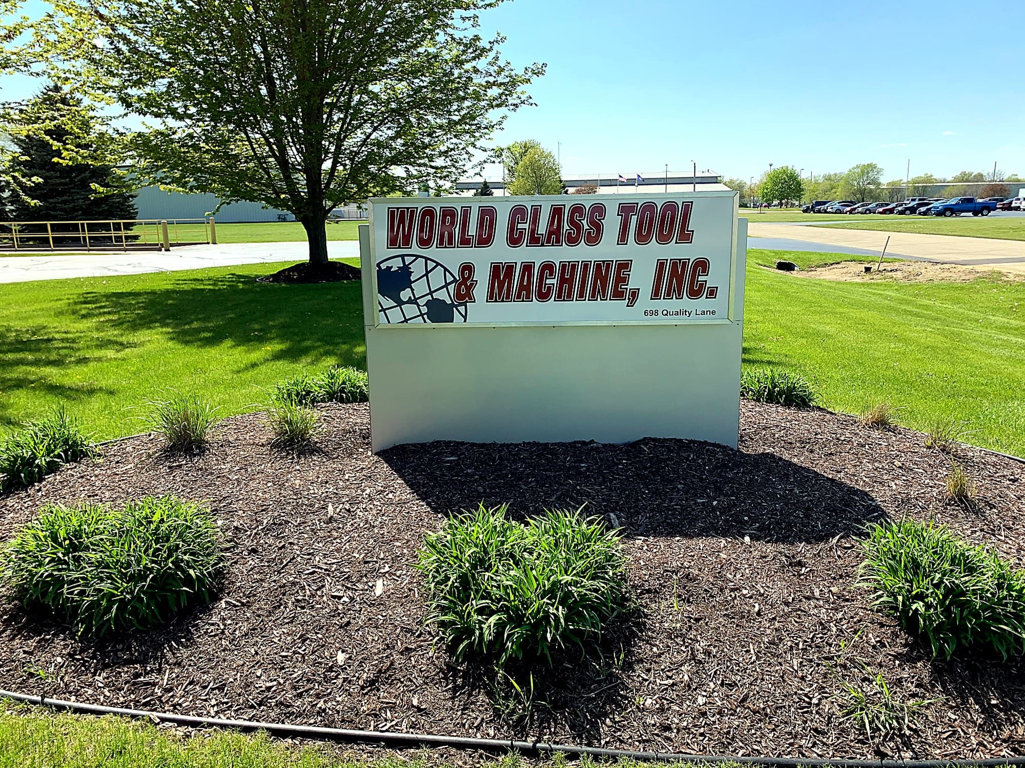 World Class Tool & Machine sign on landscaped lawn.