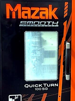 Close crop of Mazak Quick Turn 100SG branding on the machine door.